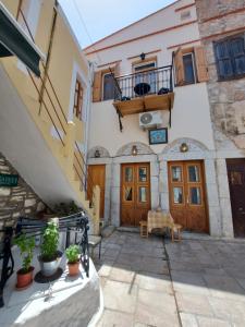 - un bâtiment avec des portes en bois et un balcon dans l'établissement Ήλιος Πατσακης, à Symi