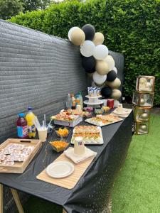 een zwarte tafel met eten en ballonnen erop bij La Suite Etoilée in Domène