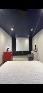 een kamer met een groot bed en een projectiescherm bij La Suite Etoilée in Domène