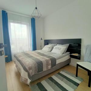 Un dormitorio con una cama grande y una ventana en Apartament PERŁA POŁUDNIA en Suwałki