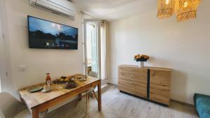 a living room with a table and a tv on the wall at Ze Perfect Place - Opera Nice - Appartement 2 Chb - AC - Terrasse in Nice