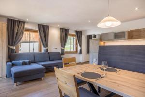 a living room with a table and a blue couch at Lechnerhof Fane Alm in Valles