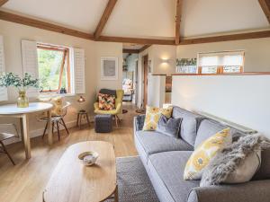 a living room with a couch and a table at Oversands Cottage in Grange Over Sands