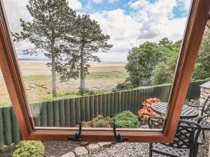 ein Spiegel, der eine Terrasse mit einem Tisch und einem Zaun reflektiert in der Unterkunft Oversands Cottage in Grange Over Sands