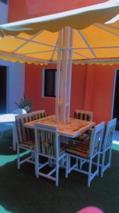 uma mesa e cadeiras debaixo de um guarda-sol em Résidence Kalado Saly em Saly Portudal