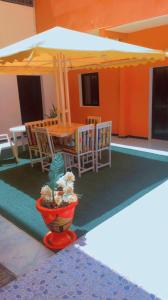 um pátio com uma mesa, cadeiras e um guarda-sol em Résidence Kalado Saly em Saly Portudal