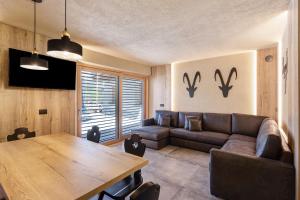 a living room with a couch and a table at Appartamento Nido in Livigno
