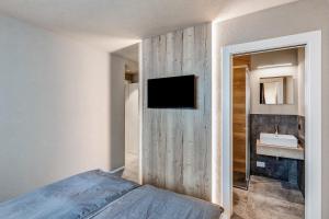 a bedroom with a bed and a tv on a wall at Appartamento Nido in Livigno