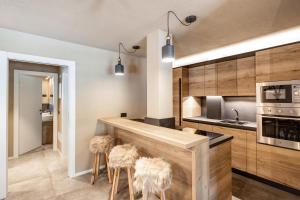 a kitchen with a counter with stools at Appartamento Nido in Livigno