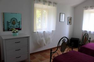 a bedroom with white walls and a dresser and a window at L'ulivo e lo scoiattolo in Marina Palmense