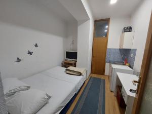 um pequeno quarto com uma cama e um lavatório em At Mejdan Rooms em Saraievo mais 11 fotografias
