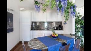 a dining room with a table and purple flowers at Luxury Lakefront Property in Lezzeno