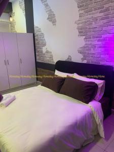 a bedroom with a white bed with purple lighting at Couples Mind Relaxing Holiday Paradise 11 in Cyberjaya +4 photos