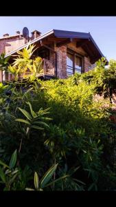 uma casa de tijolos com uma varanda no topo de alguns arbustos em Splendido cottage Lakeview em Bellagio