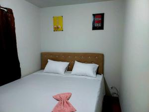 a bedroom with a bed with a pink towel on it at Apartamento próximo ao Autódromo. in Londrina