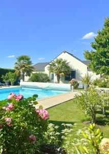 a house with a swimming pool in a yard at Gîte pause au jardin in Saint-Branchs