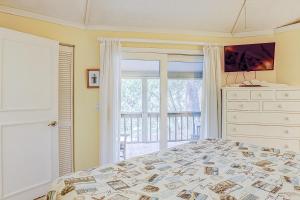 a bedroom with a bed and a window at Night Heron 35 in Hilton Head Island +23 photos