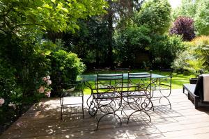 d'une terrasse avec une table et des chaises dans le jardin. dans l'établissement La Villa Mora SPA, à Lisieux