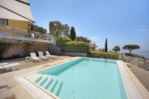 a large blue swimming pool next to a building at Villa Gaia in Bordighera