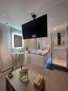 a large bathroom with a tub and a sink at La Suite Etoilée in Domène