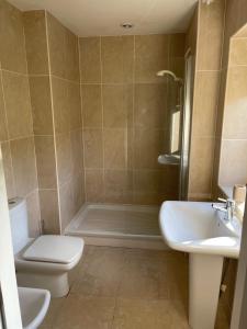 a bathroom with a toilet and a sink and a shower at Simon’s Seat View in Skipton