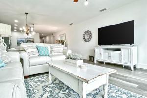 ein Wohnzimmer mit einem weißen Sofa und einem TV in der Unterkunft Madeira del Mar 303 in St Pete Beach