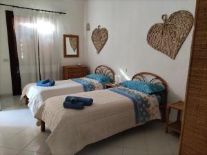 2 camas en una habitación con corazones en la pared en Villa Orchidea, en San Stèfano