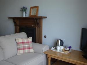 a living room with a couch and a coffee table at Glanllifon B&B in Criccieth