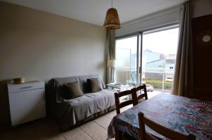 sala de estar con sofá y mesa en Appartement au pied de la plage - Balcon - Parking, en Courseulles-sur-Mer