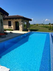 a blue swimming pool in front of a house at Private Villa at BlackSeaRama Golf & Villas Resort in Balchik