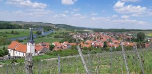 a village with a fence and a town with a river at Ferienwohnung Rosenberger in Kolitzheim
