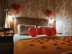 Una cama con globos de corazón rojos encima. en Yıldız Hotel, en Ürgüp