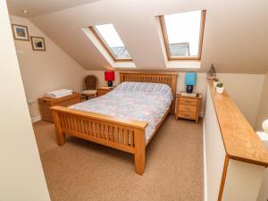 a bedroom with a bed and two windows at Sunswept in St Austell