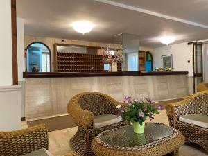 a room with chairs and a table with flowers on it at Hotel San Pietro in Letojanni