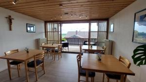 ein Esszimmer mit Tischen und Stühlen und ein Balkon in der Unterkunft Privatpension Eberth in Bogen