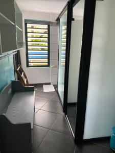 una cucina con porta in vetro, tavolo e sedia di Plumeria holidays a Saint-Pierre
