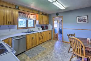 a kitchen with wooden cabinets and a wooden table and a table and chairs at Classic Mountain Home, Half Mi to Main Street in Lead +25 photos