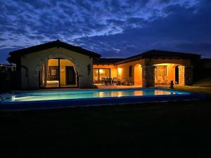 uma casa com piscina à noite em Private Villa at BlackSeaRama Golf & Villas Resort em Balchik