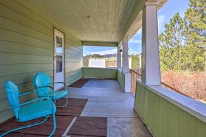 une terrasse couverte avec 2 chaises bleues sur une maison dans l'établissement Classic Mountain Home, Half Mi to Main Street, à Lead