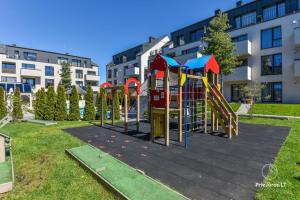 un parco giochi in un parco di fronte a un edificio di Apartamentai Malūno vilose a Palanga