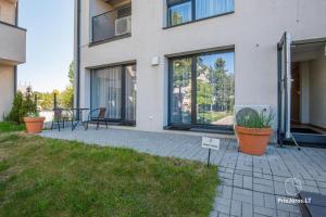 una casa con patio arredato con tavolo e sedie di Apartamentai Malūno vilose a Palanga
