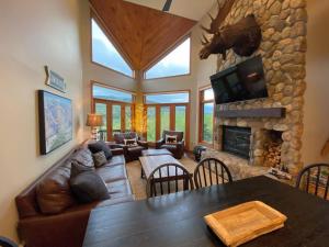 een woonkamer met een bank en een stenen open haard bij C12 Homey Bretton Woods slopeside townhome for your family getaway to the White Mountains in Carroll