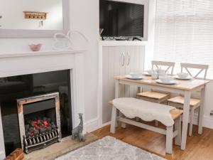 a living room with a table and a fireplace at Ermysted's Cottage in Skipton +11 photos