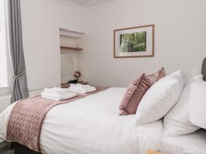 a bedroom with a bed with white sheets and pillows at Ermysted's Cottage in Skipton
