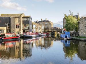 a group of boats in a river in a city at Ermysted's Cottage in Skipton