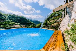 a pool with a yellow bench and a water fountain at Villa Le Murelle in Tramonti
