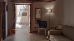 un soggiorno con un divano e una televisione di Casa vacanza U Curtigghiu a Città di Lipari