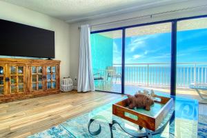 ein Wohnzimmer mit einem Flachbild-TV und einem großen Fenster in der Unterkunft Chateaux Sunset Suites 408 in Clearwater Beach