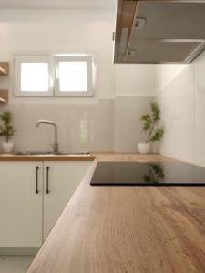 a kitchen with white cabinets and a wooden counter top at Villa Areti in Lefkimmi