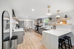 una cocina con encimeras blancas y una isla de cocina con taburetes en Blue Bungalow In Houston Heights! Walkable to Popular Bars, en Houston 13 fotos más